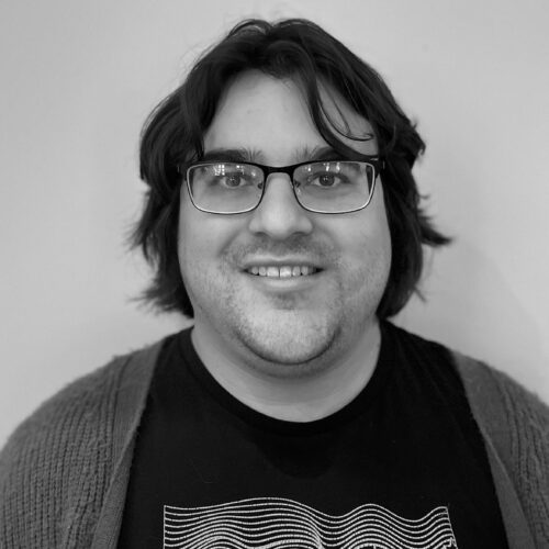 black and white photo of Thomas Osorio (man in glasses with black shirt)
