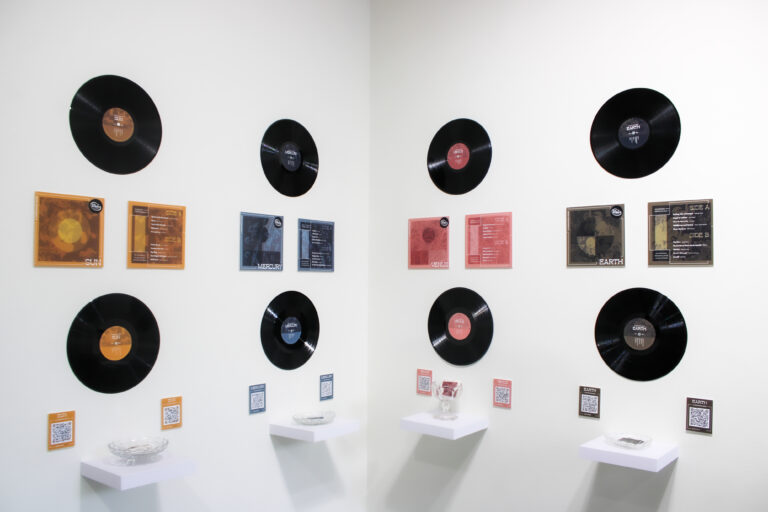 Vinyl records on white walls with each vinyl representing a planet designed by Trinity Stewart