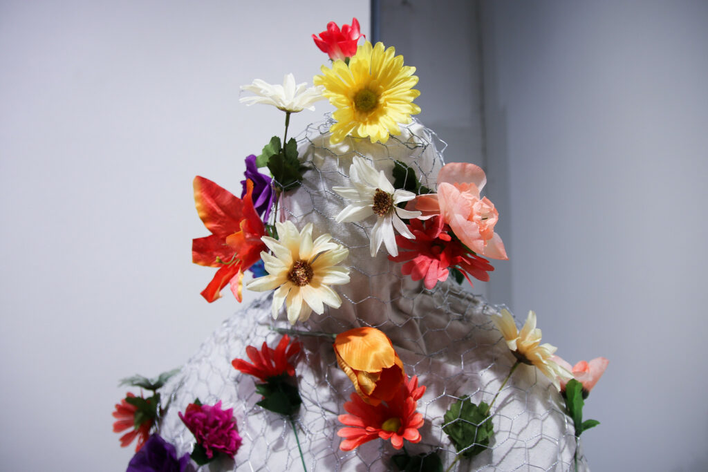 a human form wrapped in chicken wire and stuffed with flowers