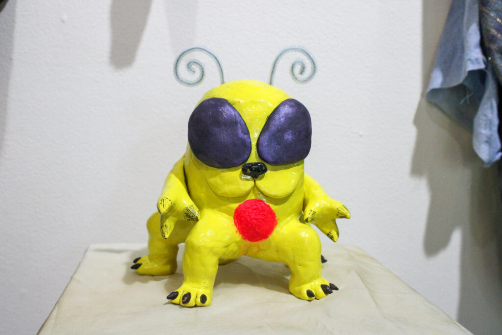 A sculpture of a cute, multi-legged bug/dog chimera monster.