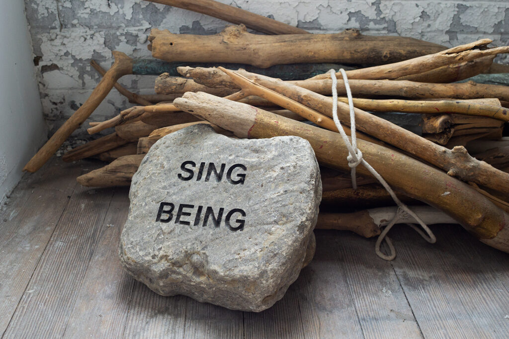 A rock with the text "Sing Being"