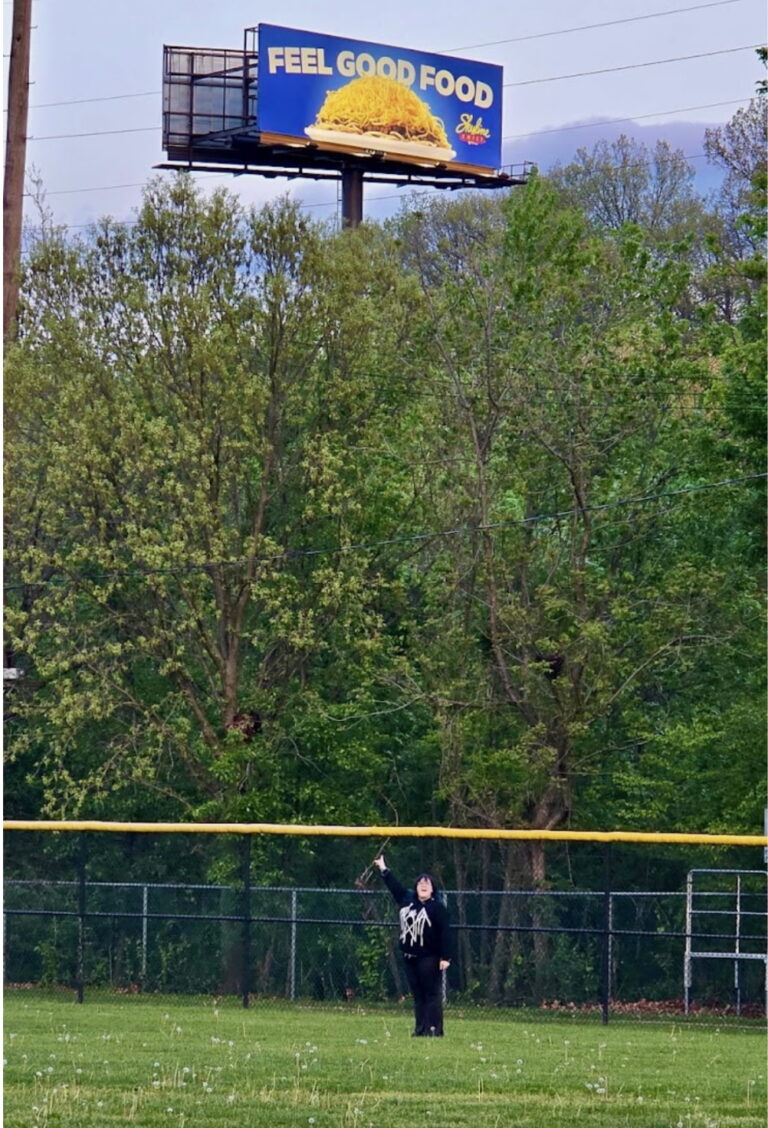 image of marci Rhodes under her billboard for Skyline Chili
