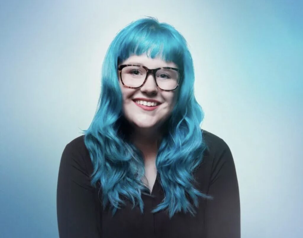 Photo of Marci Rhodes with Blue Hair and glasses