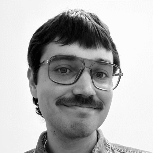 man in glasses with mustache grinning