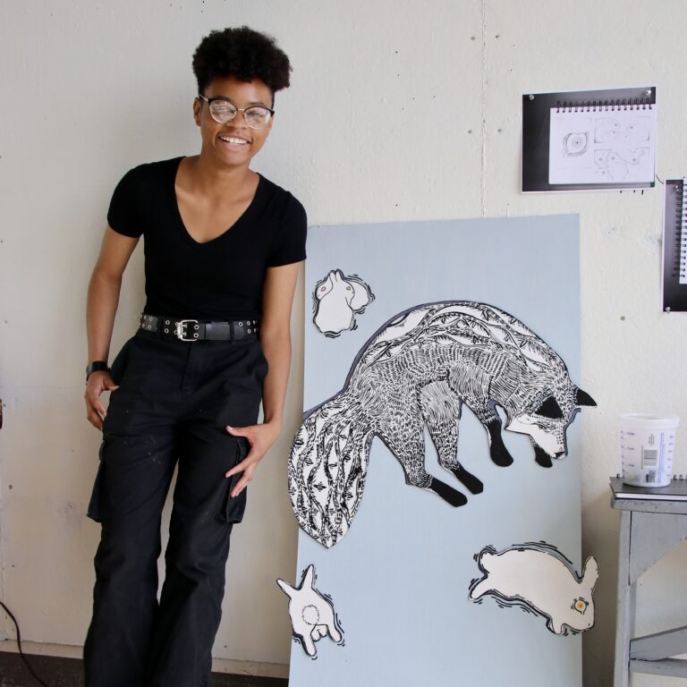 teen standing next to art