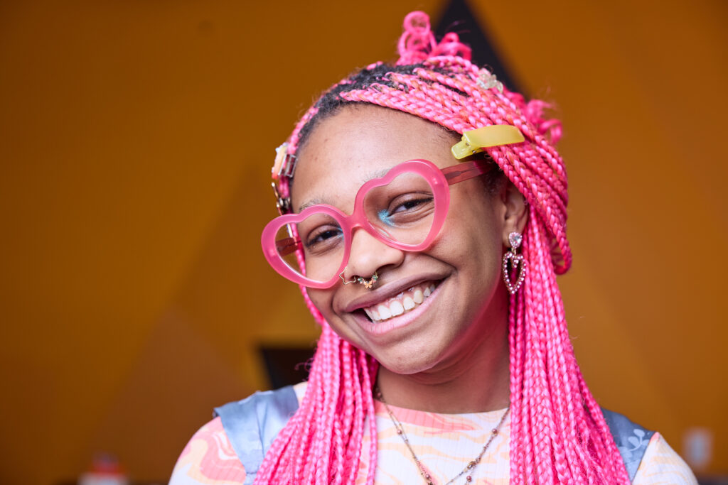 woman with pink hair smiling