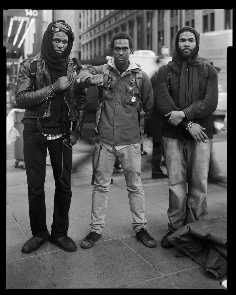 black and white photo of three men by Accra Shepp