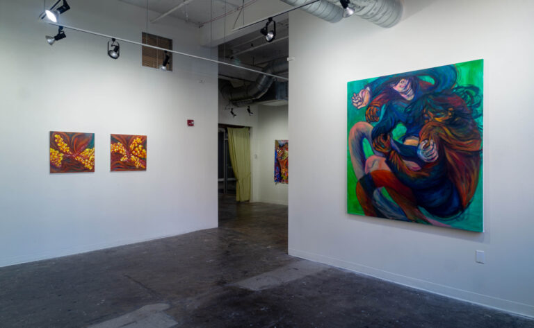 three paintings hanging in a gallery